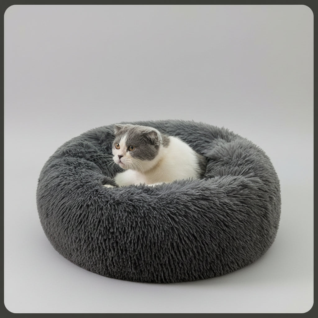 Cat lying on a fluffy gray pet bed in a home setting
