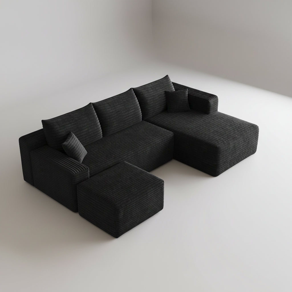 Black sectional sofa in a living room with a coffee table and decorative items.
