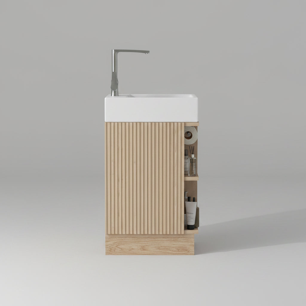 Bathroom vanity with wooden cabinet and white sink against a light green wall.